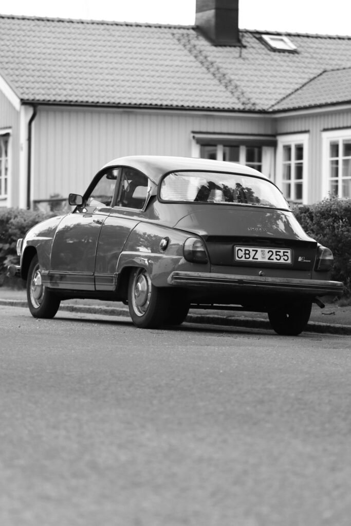 A classic Saab car in black and white parked in Hjo, Sweden's picturesque suburb.
