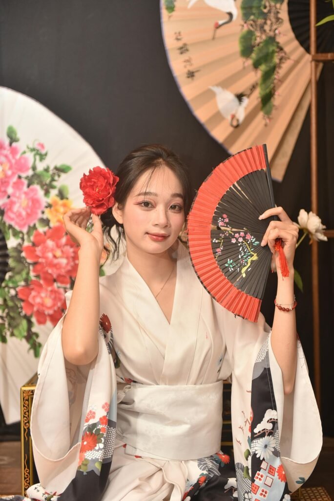 Young woman in a kimono holding a fan, surrounded by decorative fans. Perfect for cultural and fashion themes.