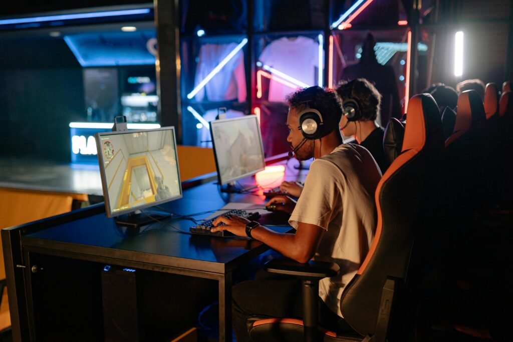 Competitive gaming session with friends indoors featuring high-tech computers and neon lights.